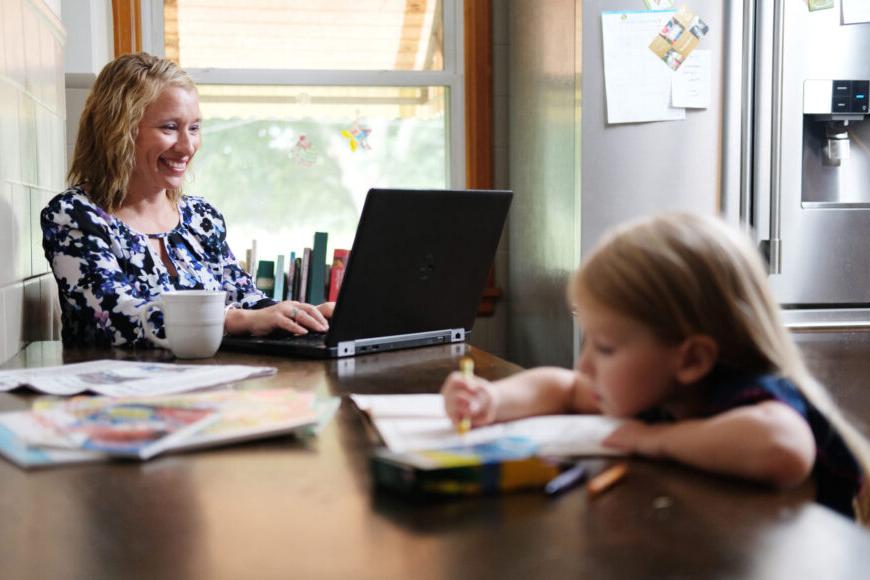 adult learner on laptop with child